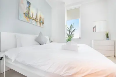 a white bedroom with a large white bed at HAVN - 1 Bedroom in Dubai Marina with Sea Views in Dubai