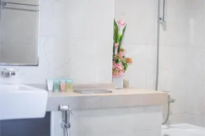 a bathroom with a counter with a vase of flowers on it at HAVN - 1 Bedroom in Dubai Marina with Sea Views in Dubai
