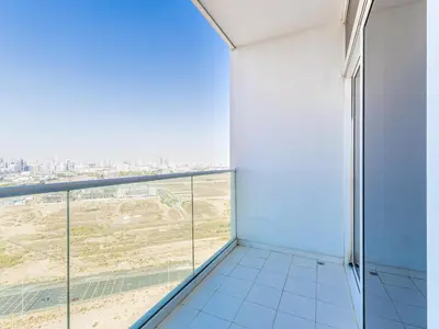 a room with a balcony with a view of the city at Studio in Damac Hills - Modern Comfort with Premium Amenities,by Think Realty in Dubai