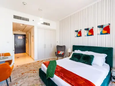 a bedroom with a bed and a desk and a chair at Studio in Damac Hills - Modern Comfort with Premium Amenities,by Think Realty in Dubai