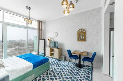a bedroom with a bed and a table and chairs at Studio in Damac Hills - Luxurious Living with Premium Amenities, by Think Realty in Dubai