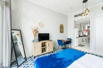 a living room with a blue rug on the floor at Studio in Damac Hills - Luxurious Living with Premium Amenities, by Think Realty in Dubai
