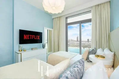 a hotel bedroom with a view of the city at LUX The Marina Vista Beachfront Suite 3 in Dubai