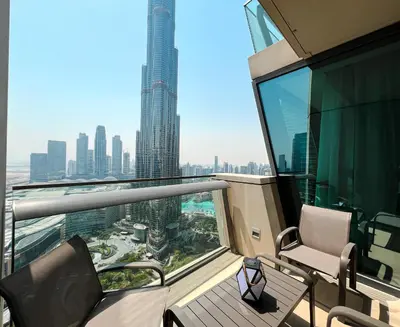 a balcony with chairs and a view of a city at Stylish 2BR Burj Khalifa & Fountain View Downtown - 37AB06 in Dubai