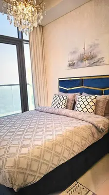 a bedroom with a large bed with a chandelier at Luxury 3 bedroom Aykon Tower in Dubai