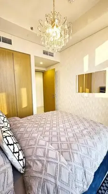 a bedroom with a large bed and a chandelier at Luxury 3 bedroom Aykon Tower in Dubai