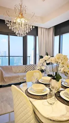 a dining room with a table with chairs and a chandelier at Luxury 3 bedroom Aykon Tower in Dubai