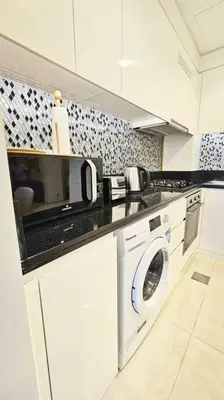 a kitchen with a washing machine and a microwave at Luxury 3 bedroom Aykon Tower in Dubai