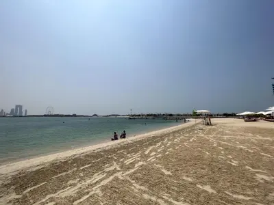 a group of people walking on a beach at Palm Jumeirah 1BR - Rooftop Infinity Pool in Dubai