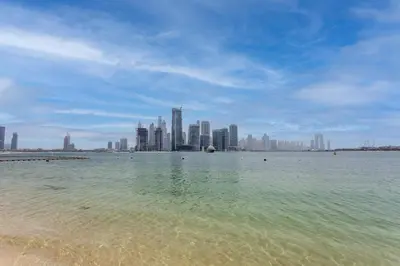 a view of a beach with a city in the background at Palm Jumeirah 1BR - Rooftop Infinity Pool in Dubai