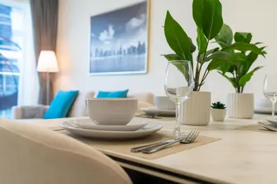 a dining room table with plates and glasses on it at Gala Guests - Deluxe Marina View Apartments with Infinity Pool in Dubai