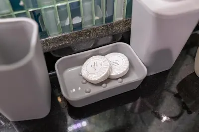 two white plates in a container in a bathroom at Gala Guests - Deluxe Marina View Apartments with Infinity Pool in Dubai