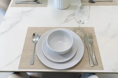 a table with a bowl and a plate and a glass at Gala Guests - Deluxe Marina View Apartments with Infinity Pool in Dubai