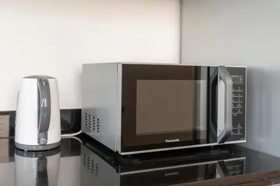 a microwave sitting on a counter next to a coffeemaker at Gala Guests - Deluxe Marina View Apartments with Infinity Pool in Dubai