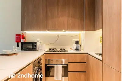 a kitchen with a stove and a microwave at 2ndHome - Laya Heights, Studio City in Dubai
