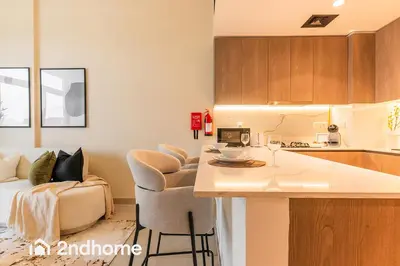 a kitchen and living room with a table and chairs at 2ndHome - Laya Heights, Studio City in Dubai