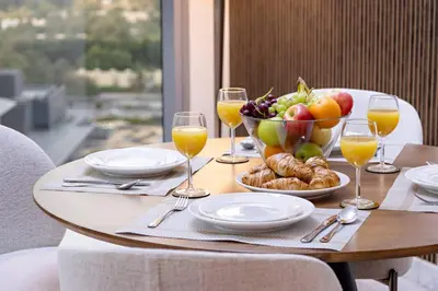 a table with a bowl of fruit and wine glasses at Luxury DIFC 1BR Near Dubai Mall, Burj Khalifa with Skyline Views in Dubai