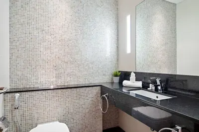 a bathroom with a sink and a toilet and a mirror at Luxury DIFC 1BR Near Dubai Mall, Burj Khalifa with Skyline Views in Dubai