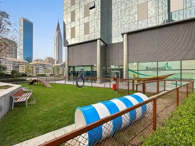 a building with a playground in front of it at Luxury DIFC 1BR Near Dubai Mall, Burj Khalifa with Skyline Views in Dubai