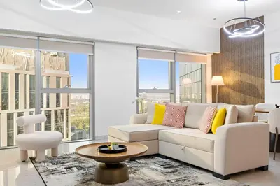 a living room with a white couch and large windows at Luxury DIFC 1BR Near Dubai Mall, Burj Khalifa with Skyline Views in Dubai