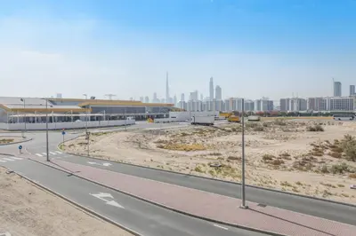 an empty road with a city in the background at Fantastic1BR Furnished Apt at Azizi Park Avenue! in Dubai