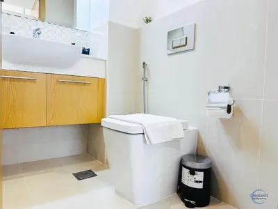 a bathroom with a white toilet and a sink at 1BR Downtown Apt Walk to Dubai Mall & Burj in Dubai