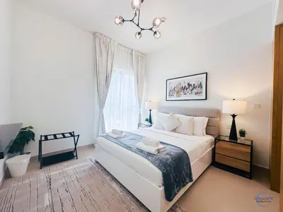 a bedroom with a large white bed and a window at 1BR Downtown Apt Walk to Dubai Mall & Burj in Dubai