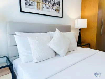 a bedroom with a white bed with white pillows at 1BR Downtown Apt Walk to Dubai Mall & Burj in Dubai