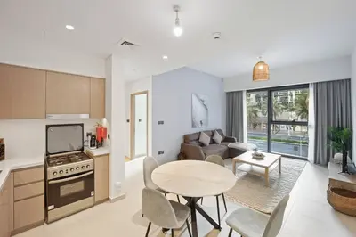 a kitchen and living room with a table and a couch at Brand New 1BR Downtown - Next to Dubai Mall in Dubai
