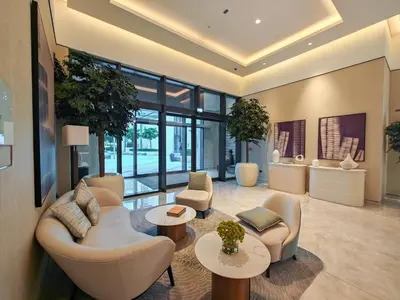a living room with chairs and tables and windows at Brand New 1BR Downtown - Next to Dubai Mall in Dubai