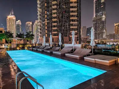 a swimming pool with a city skyline in the background at Brand New 1BR Downtown - Next to Dubai Mall in Dubai