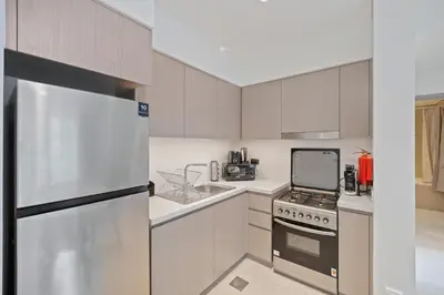 a kitchen with a stove and a refrigerator at Brand New 1BR Downtown - Next to Dubai Mall in Dubai