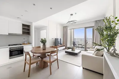 a kitchen and living room with a table and chairs at Silkhaus Elegant 1BDR in Downtown Views II in Dubai