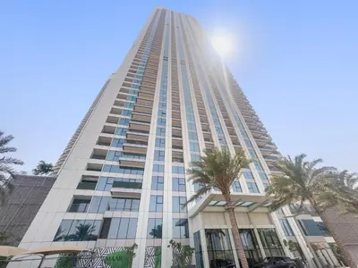 a tall building with palm trees in front of it at Silkhaus Elegant 1BDR in Downtown Views II in Dubai