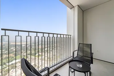 a balcony with two chairs and a large window at Silkhaus Elegant 1BDR in Downtown Views II in Dubai