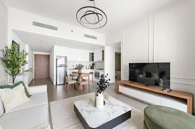 a living room with a white couch and a tv at Silkhaus Elegant 1BDR in Downtown Views II in Dubai