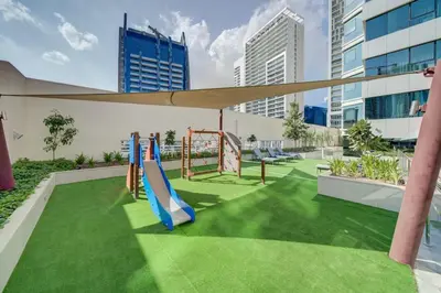 a playground with a slide and a swing at Stylish studio with storage room in hotel l Fits 2 in Dubai