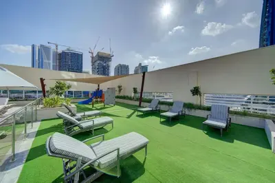 a group of chairs and tables on the roof of a building at Stylish studio with storage room in hotel l Fits 2 in Dubai