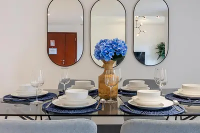 a dining room with a table with plates and mirrors at Vacationer I Premium 3 Bedroom Apartment I Steps Away from JBR Beach in Dubai