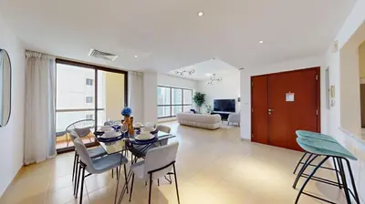 a dining room and living room with a table and chairs at Vacationer I Premium 3 Bedroom Apartment I Steps Away from JBR Beach in Dubai
