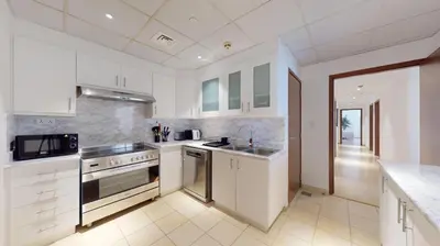 a kitchen with white cabinets and a stove top oven at Vacationer I Premium 3 Bedroom Apartment I Steps Away from JBR Beach in Dubai