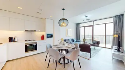 a kitchen and living room with a table and chairs at Palace Residences - Chic Two Bed with Creek Views in Dubai