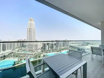 a balcony with a table and chairs and a view of a city at Palace Residences - Chic Two Bed with Creek Views in Dubai