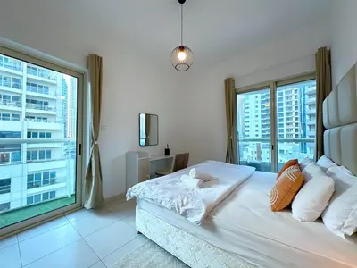 a bedroom with a bed with a large window at DreamLike Full Pool & Marina View Apartment Dubai in Dubai