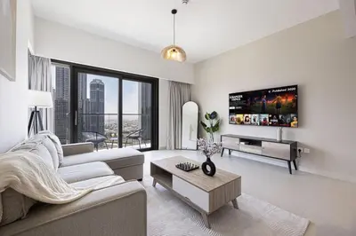 a living room with a couch and a tv at LUXE | 2BR | Sea & City View | 5 Min to Dubai Mall in Dubai