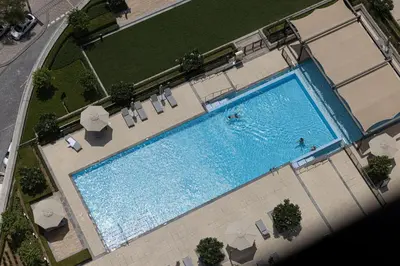 an overhead view of a swimming pool with chairs and umbrellas at LUXE | 2BR | Sea & City View | 5 Min to Dubai Mall in Dubai