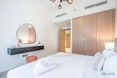 a bedroom with a large white bed and a mirror at Stunning 1BR Apartment in Azizi Riviera 42, Al Merkadh by Deluxe Holiday Homes in Dubai