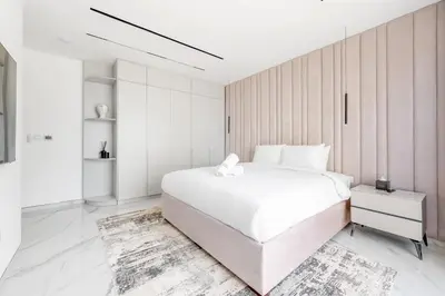 a white bedroom with a large white bed and white walls at Seaside Elegance - NEW Luxury 3-Bedroom Apt in JBR in Dubai