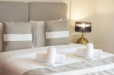 a white bed with towels on top of it at Dubai Eye & Sea View, 1-min walk to JBR Beach, Luxurious Beach Retreat! in Dubai