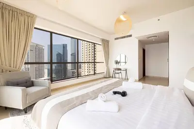 a bedroom with a large white bed with a large window at Dubai Eye & Sea View, 1-min walk to JBR Beach, Luxurious Beach Retreat! in Dubai